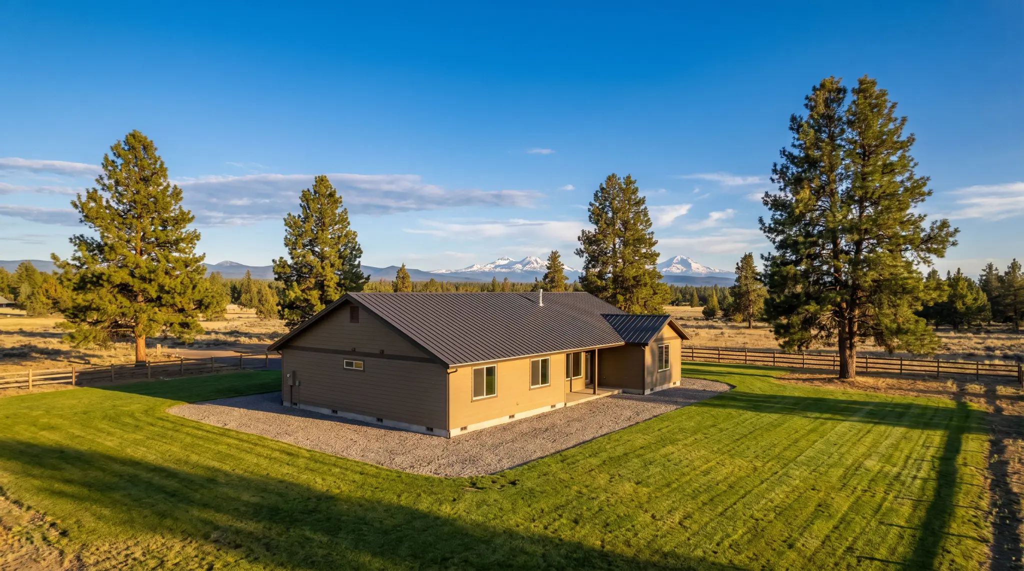 Central Oregon ranch home with defensible space and Three Sisters mountains in background